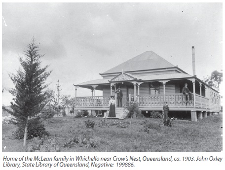 A black-and-white photo showing an historic Queensland house with a wide verandah. A woman in a long skirt is standing on the front steps and two men are on the verandah while another stands in front of the house.